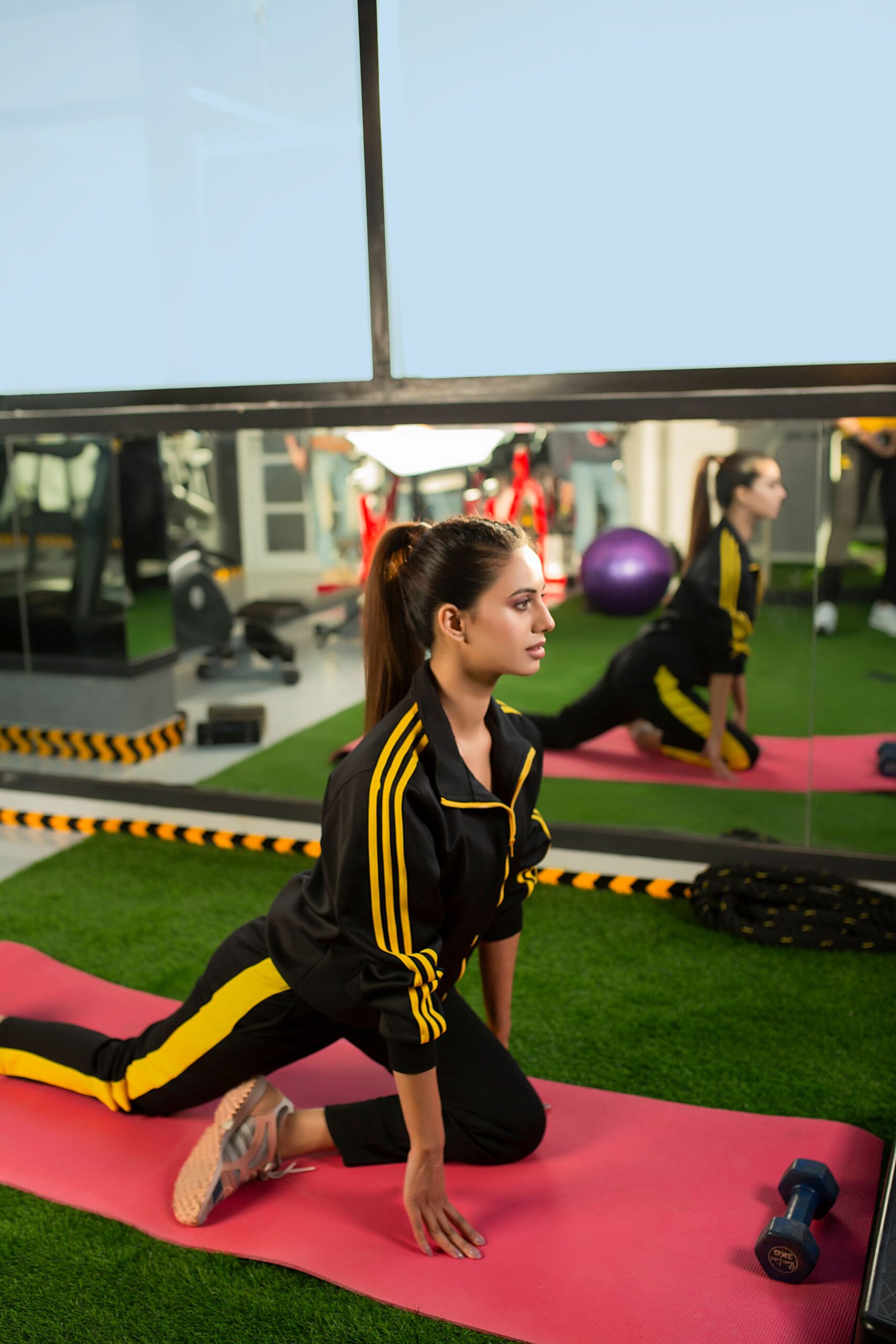Men and women wearing premium gym clothing including leggings, tank tops, fitness shirts, gym hoodies, fitness bras, and active wear sets during workouts.